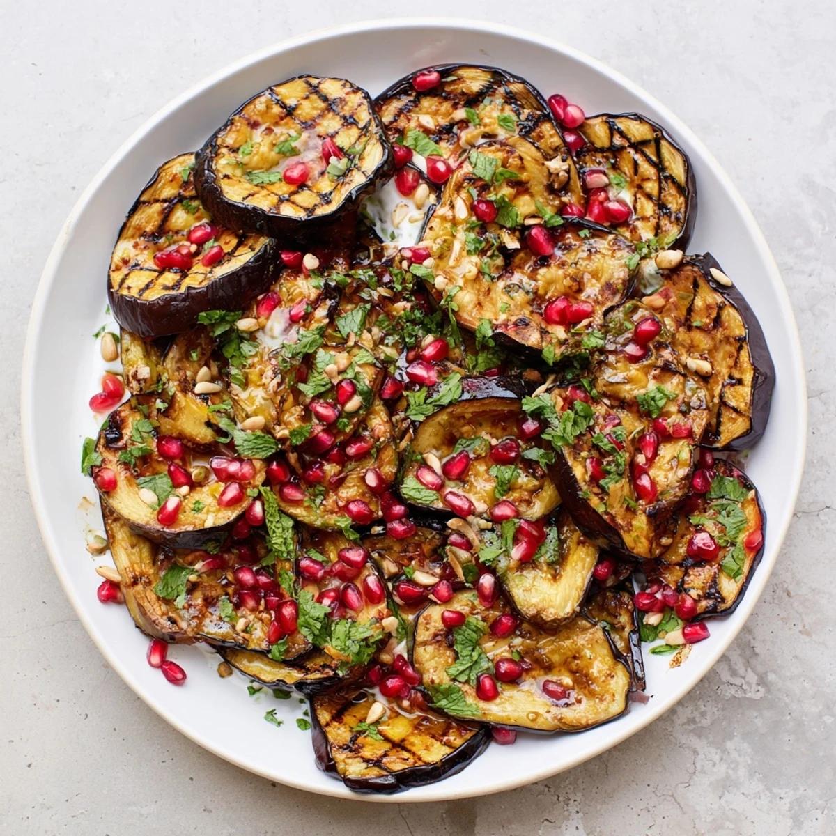 A beautifully plated roasted eggplant recipe, featuring a colorful mix of herbs and a savory yogurt drizzle.