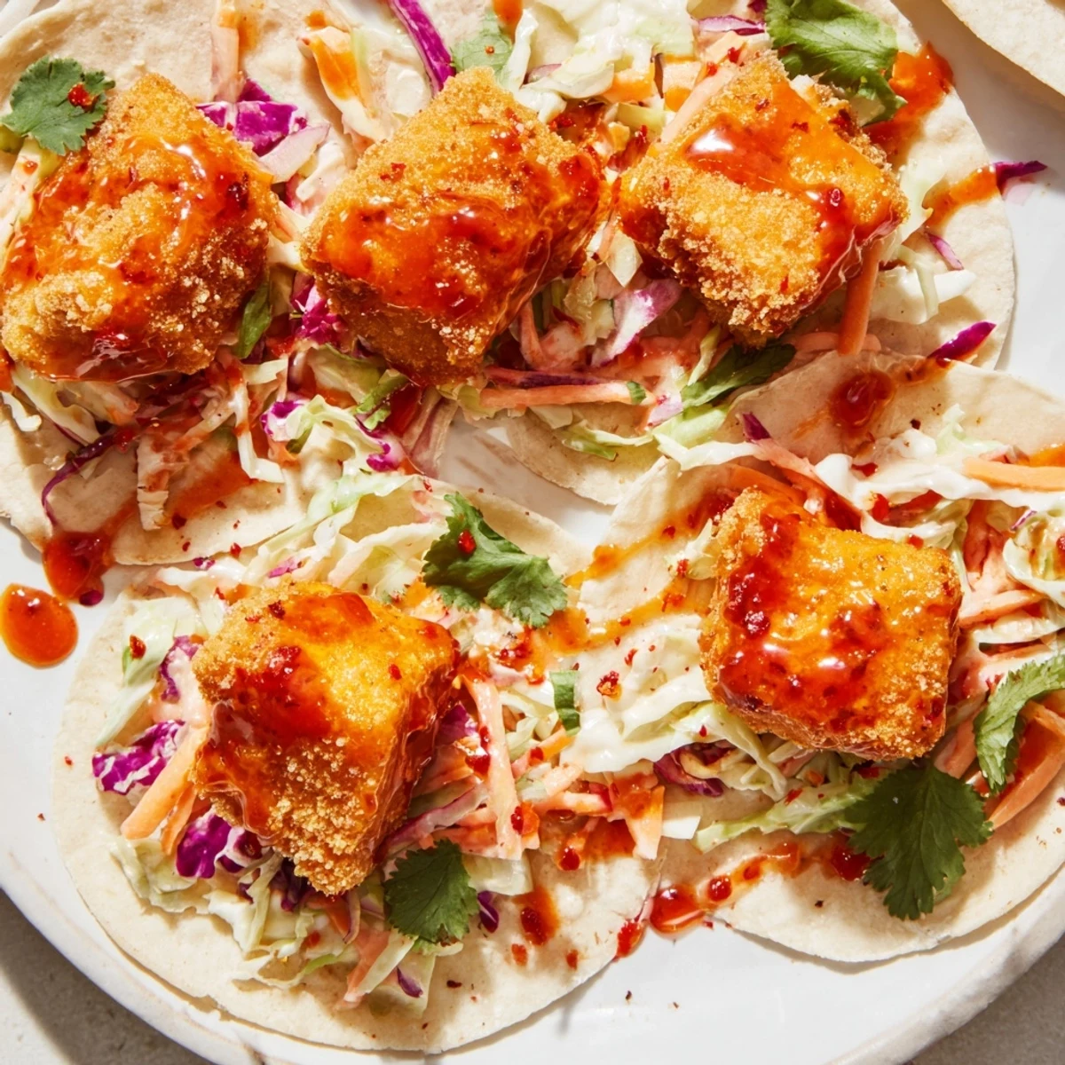 Golden, crispy Hot Honey Chicken Tacos, drizzled with spicy honey and featuring fresh, cool slaw.