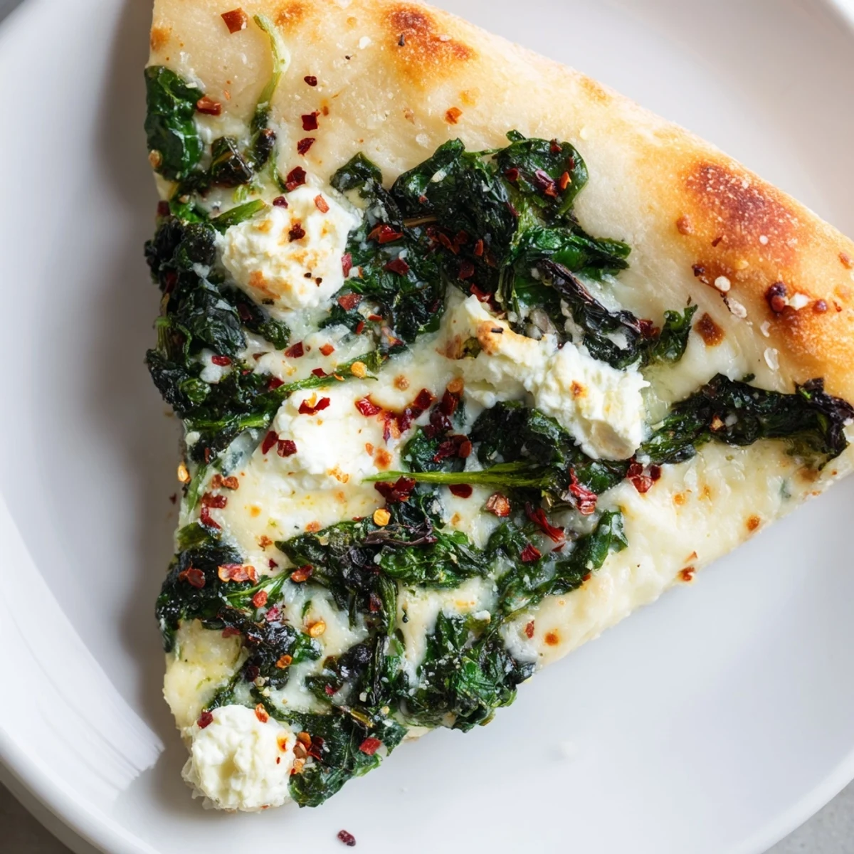 Freshly baked Spinach Ricotta Pizza on a wooden board, featuring golden-brown crust with creamy dollops of ricotta and sautéed spinach.