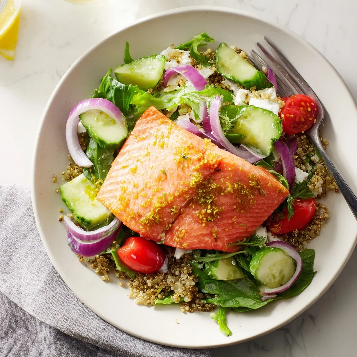 A close-up of Lemon Herb Salmon Salad with flaky baked salmon, quinoa, and crisp greens in a zesty citrus vinaigrette, ready to serve.  