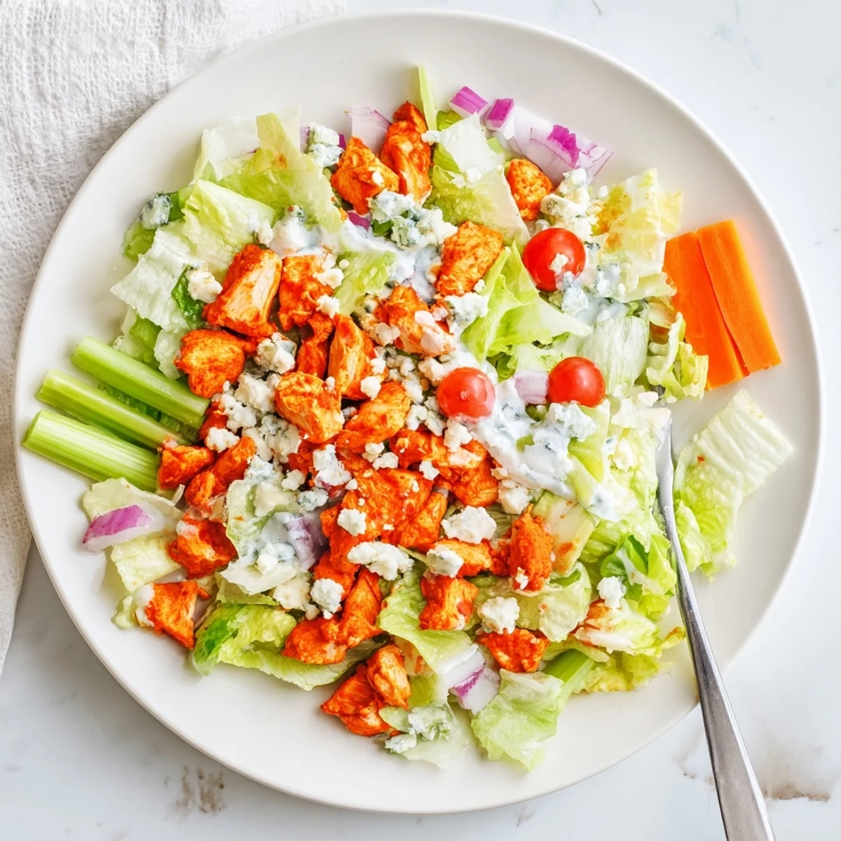 Deconstructed Buffalo Chicken Chopped Salad featuring tender spicy chicken, colorful vegetables, and a drizzle of ranch dressing.