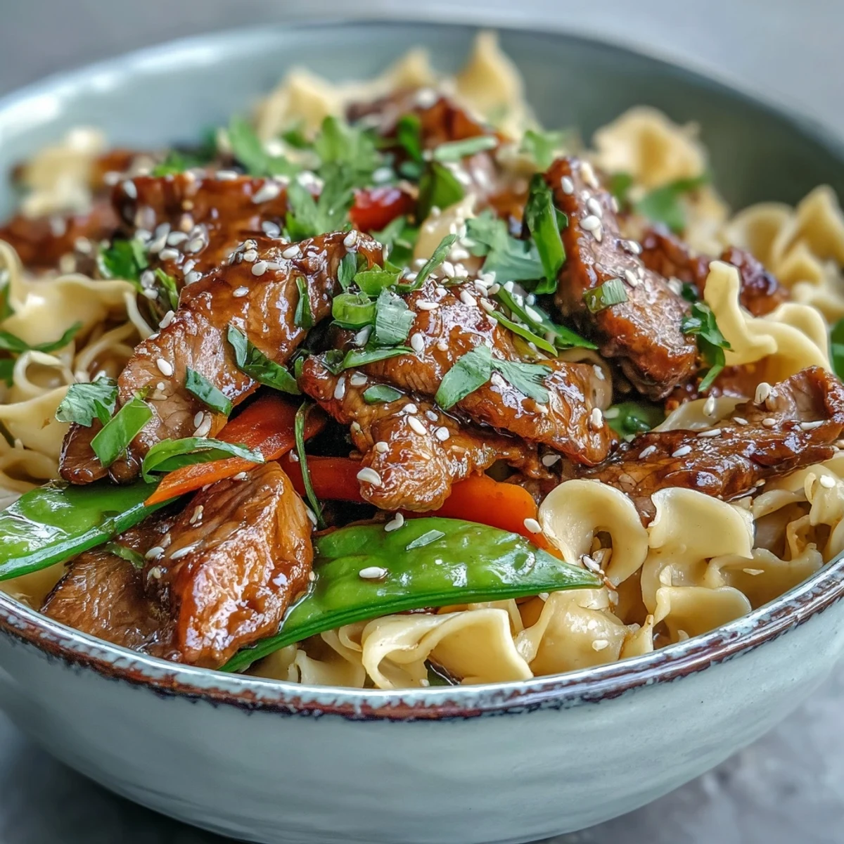 Sizzling slices of marinated pork and crisp veggies mingle with noodles in a savory sauce in this Pork Noodle Stir-Fry.