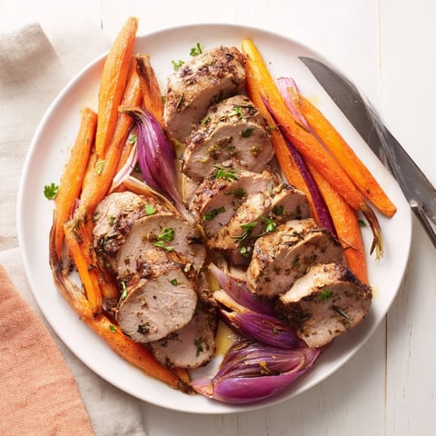One-pan garlic herb pork tenderloin and carrots roasted with fresh herbs and sweet carrots.