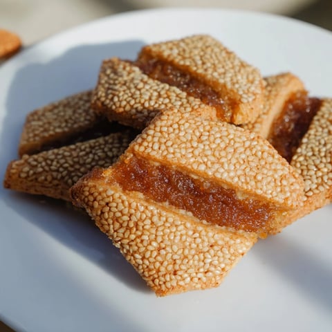 Golden Makroudh cookies, crispy semolina pastries filled with spiced dates, ready for enjoying.