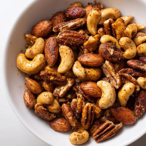 Golden roasted Spiced Nuts Mix with cumin and paprika in a rustic bowl.