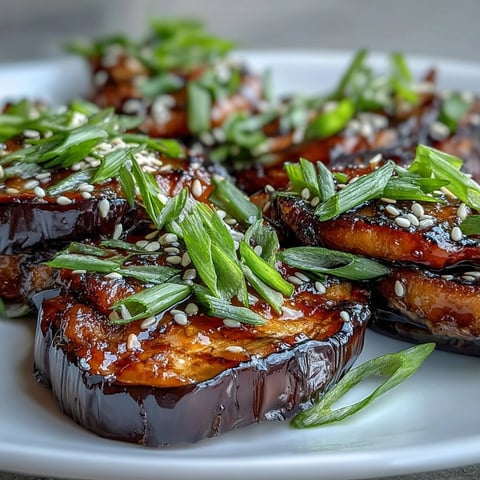 Silky roasted Miso Glazed Eggplant halves glisten with caramelized glaze and sesame seeds.