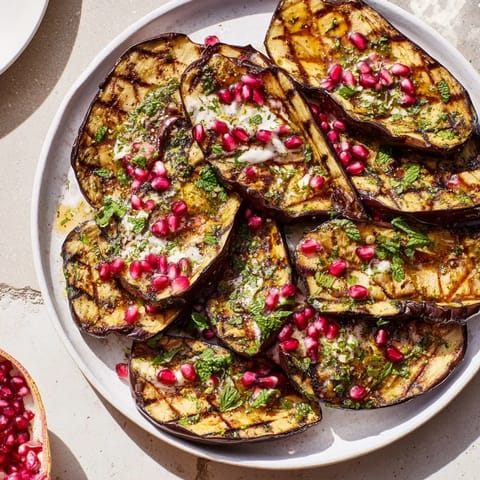 Delicious roasted eggplant dish is brimming with juicy pomegranate seeds, complementing the tangy yogurt.