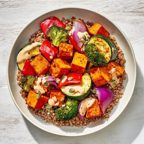 A delicious and healthy Hearty Roasted Vegetable and Farro Grain Bowl, drizzled with creamy lemon-tahini dressing.