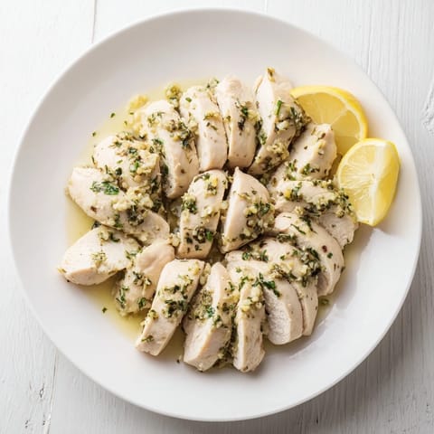 This photo shows a close-up of tender Greek Lemon Herb Chicken, ready to be enjoyed with flavorful herbs.