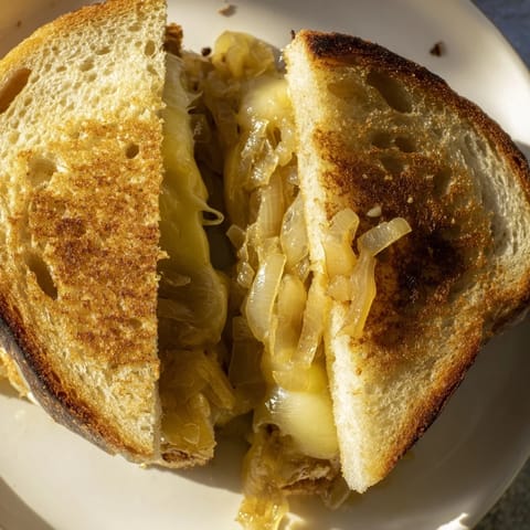 Perfectly browned Caramelized Onion and Gruyère Grilled Cheese, ready to be sliced and enjoyed.