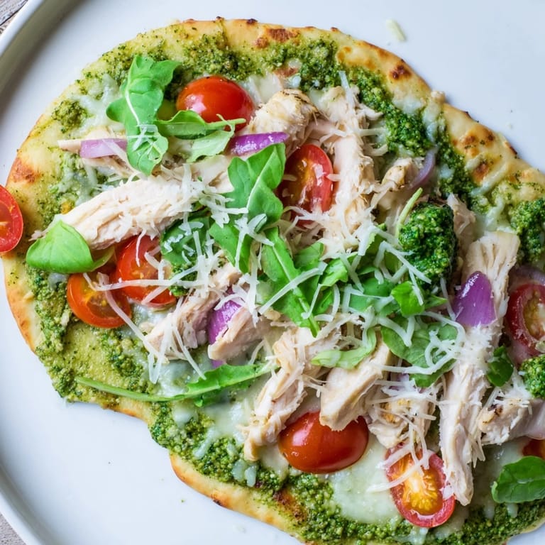 Savory pesto chicken flatbread featuring a colorful mix of toppings and a delightful, crispy crust.