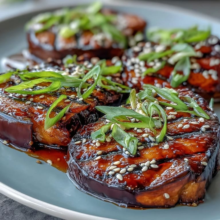 Tender Japanese eggplant with golden, broiled miso glaze, garnished with green onions.
